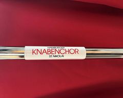 Aufkleber an einer Stange mit dem Text Hamburger Knabenchor St. Nikolai, im Hintergrund das Rot der Kutten